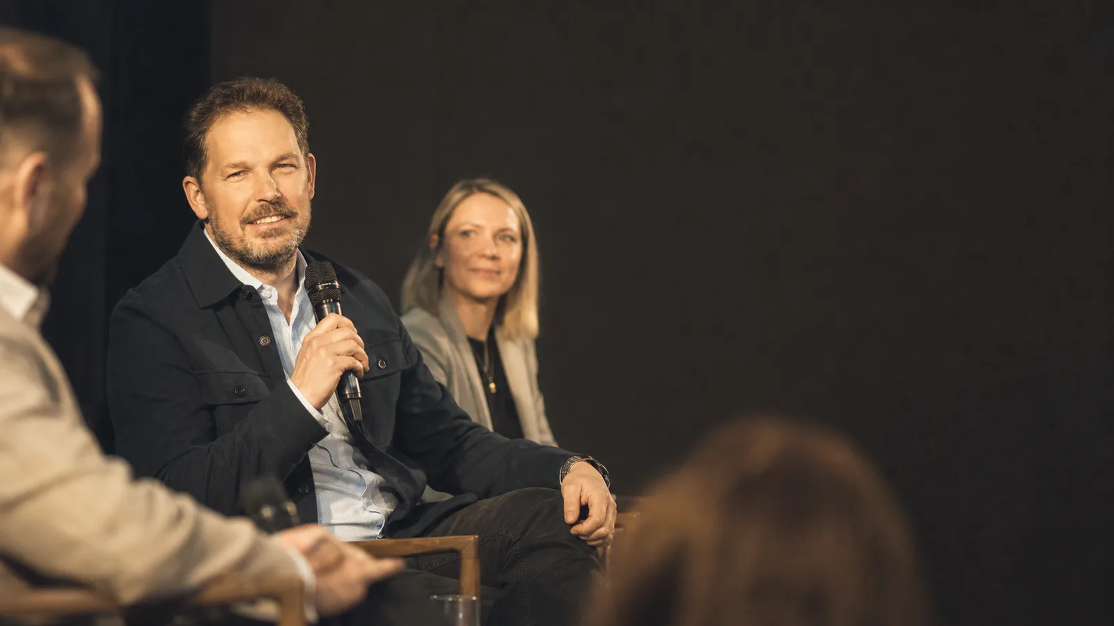 Seb Brault speaking with a microphone on a conference panel.